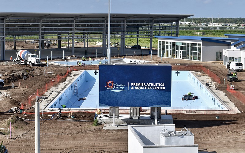 The pools are waiting on water, and the shaded pickleball structure behind them is waiting on paint for the courts.
