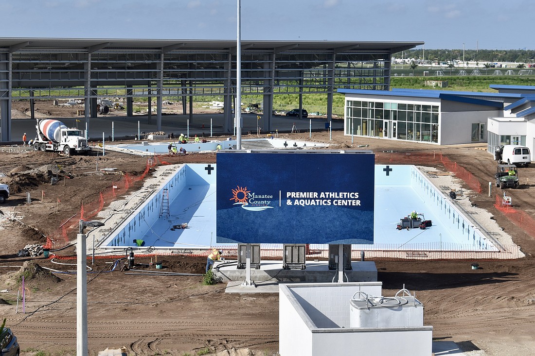 The pools are waiting on water, and the shaded pickleball structure behind them is waiting on paint for the courts.
