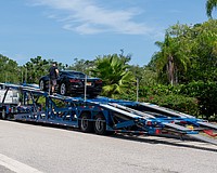 A car carrier operator unloads a Corvette on Bay Isles Road, the town of Longboat Key’s designated dropoff and pickup area for car carriers.