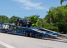 A car carrier operator unloads a Corvette on Bay Isles Road, the town of Longboat Key’s designated dropoff and pickup area for car carriers.