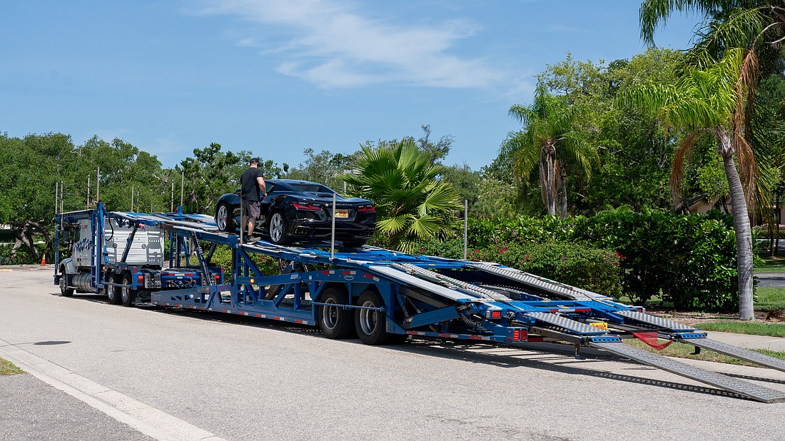 A car carrier operator unloads a Corvette on Bay Isles Road, the town of Longboat Key’s designated dropoff and pickup area for car carriers.