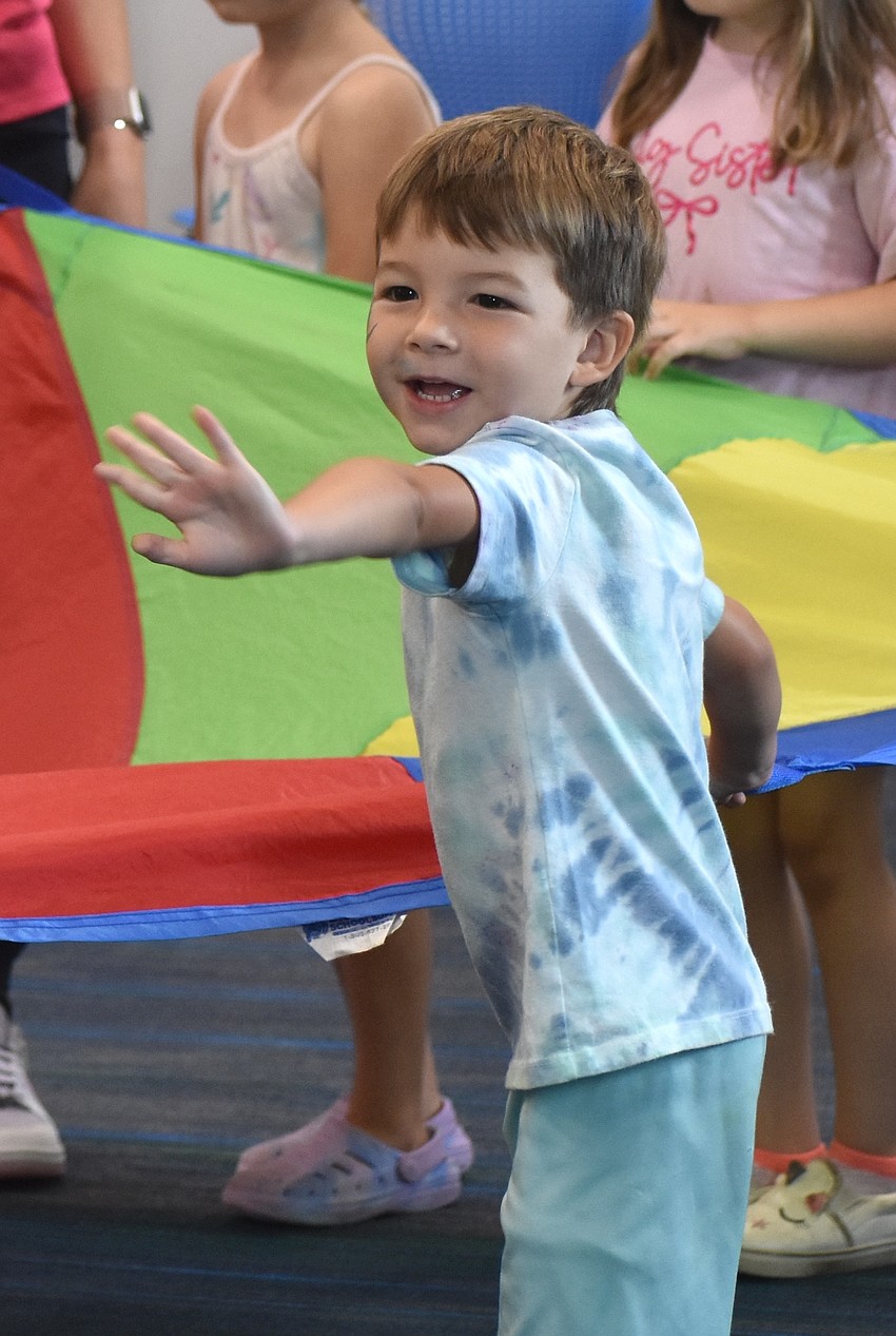 Lakewood Ranch's Aiden Quijano, 3, waves to his mother, Aimee Quijano, while participating in an activity presented by Jessica Kirby of The Little Gym of Sarasota.
