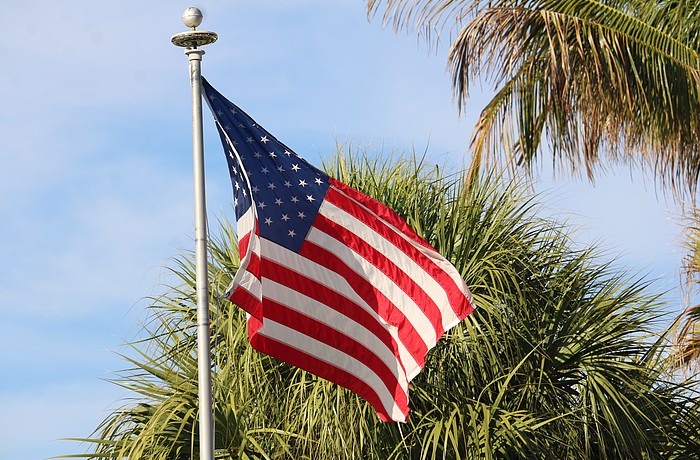An American flag flies on Gulf of Mexico Drive, the town’s main thoroughfare that will soon see much more red, white and blue as the town prepares to install 56 light pole banners.