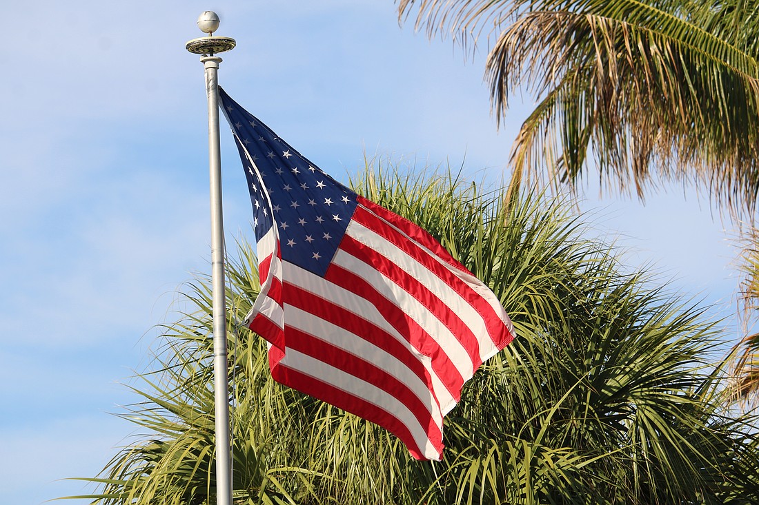 An American flag flies on Gulf of Mexico Drive, the town’s main thoroughfare that will soon see much more red, white and blue as the town prepares to install 56 light pole banners.