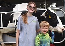 Gabrielle Finnegan, chapter president of the Lakewood Ranch High School Future Farmers of America, checks out Lucy the cow with 7-year-old camper Luca Bellantonio.
