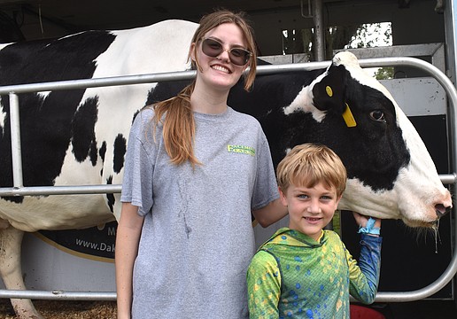 Gabrielle Finnegan, chapter president of the Lakewood Ranch High School Future Farmers of America, checks out Lucy the cow with 7-year-old camper Luca Bellantonio.
