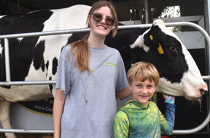 Gabrielle Finnegan, chapter president of the Lakewood Ranch High School Future Farmers of America, checks out Lucy the cow with 7-year-old camper Luca Bellantonio.