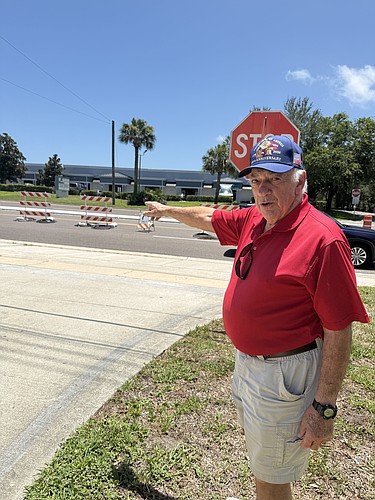 Prince of Peace parishioner John Malafronte points to the new median that blocks left-hand turns from the eastbound lanes onto the church property. Courtesy photo