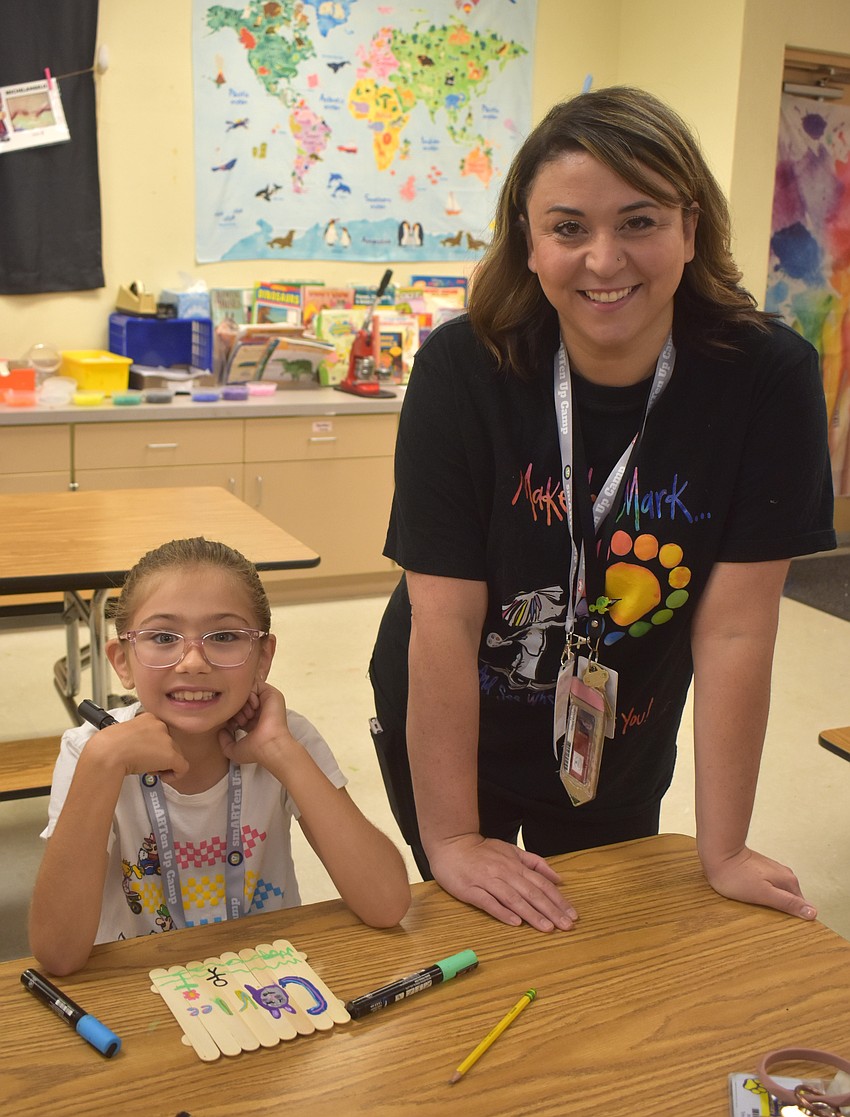 Carlee Hernandez, a rising third grader at Gene Witt Elementary School, creates an art project inspired by graffiti with the help of Braden River Elementary Art Teacher Rebecca Misla.