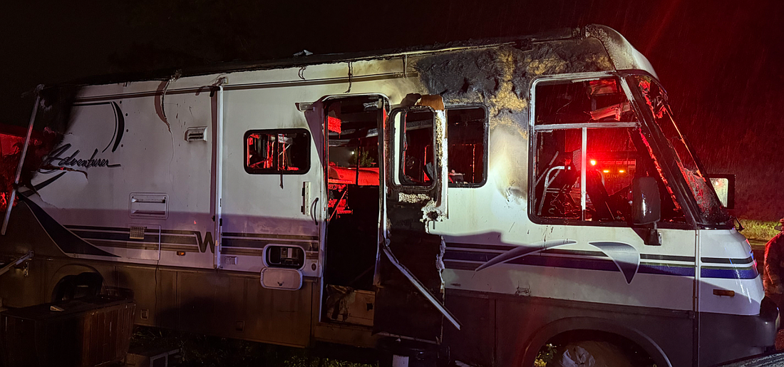 A recreational vehicle sits heavily damaged after a late-night fire on Lake Drive in Bunnell.