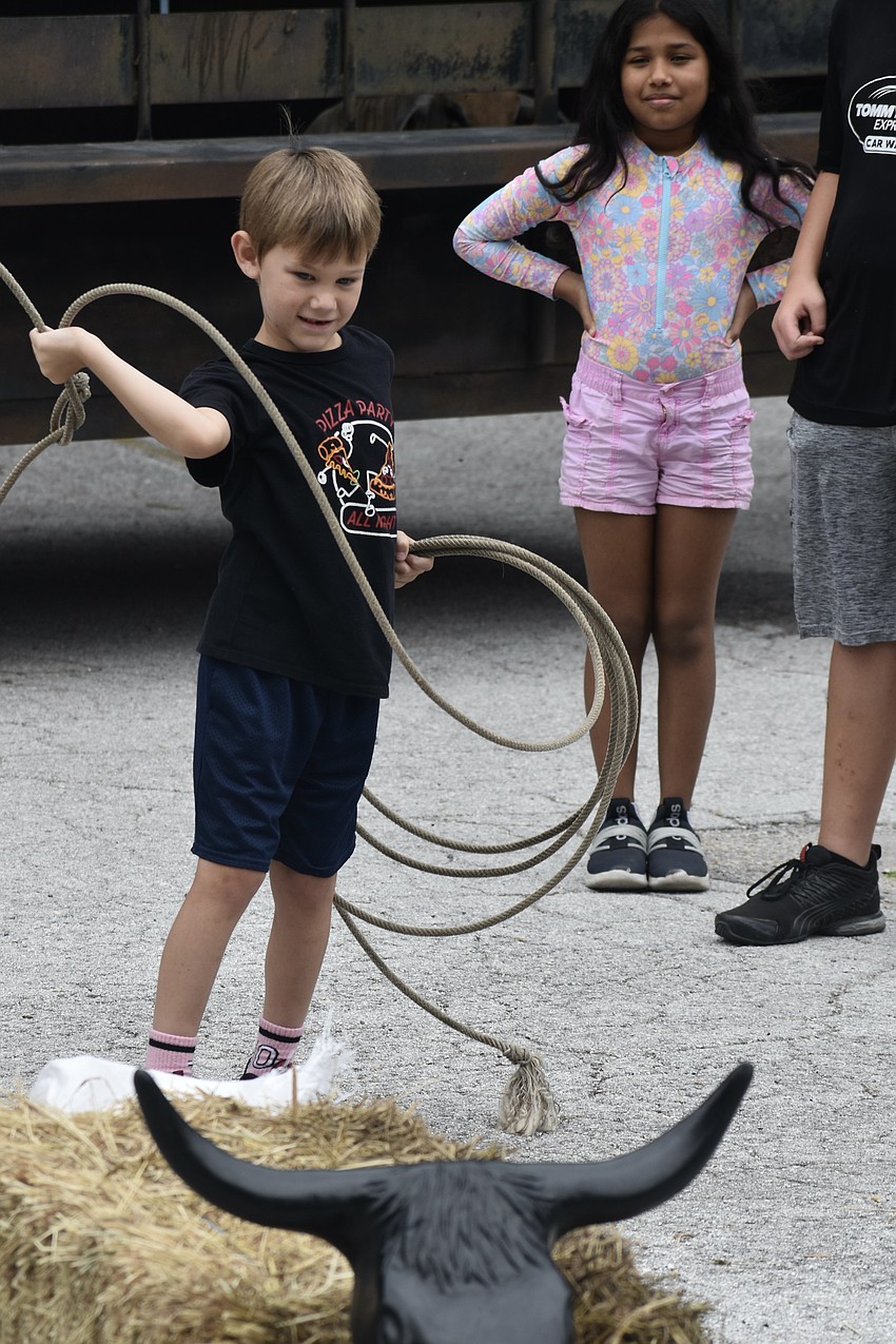 Peter Calnan, 6 tries the lasso as Antonella Rojas, 9, waits for her turn.