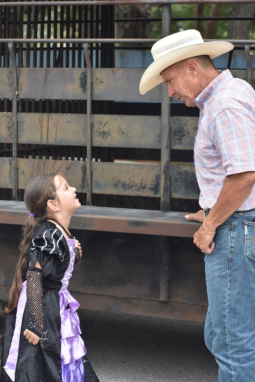 Vanessa Cruz, 5, suggests a name for the Brahman calf to Robbie Martin.
