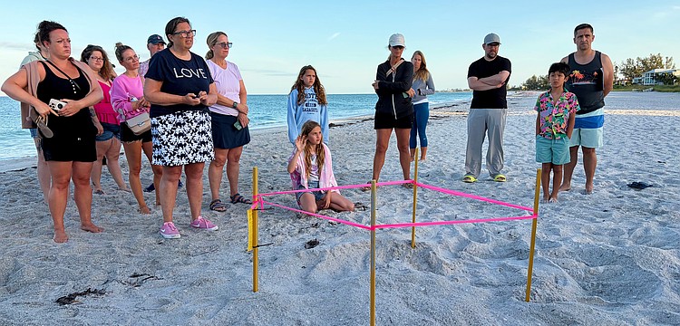 Members of the public curious to learn more about Longboat Key's sea turtle population ask questions of the experts at the first Turtle Walk of the nesting season on June 6 beside the newly staked nest.