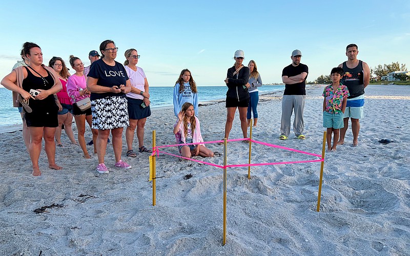 Members of the public curious to learn more about Longboat Key's sea turtle population ask questions of the experts at the first Turtle Walk of the nesting season on June 6 beside the newly staked nest.