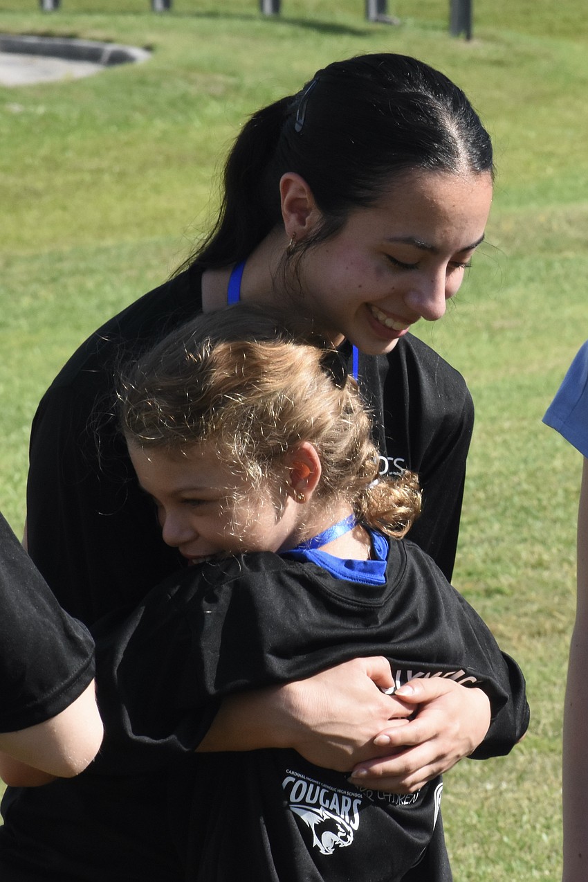 Isabella DeCarlo, a junior, hugs Emmy, 12.
