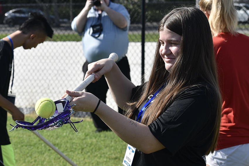 Trish, 19, makes a catch in lacrosse.