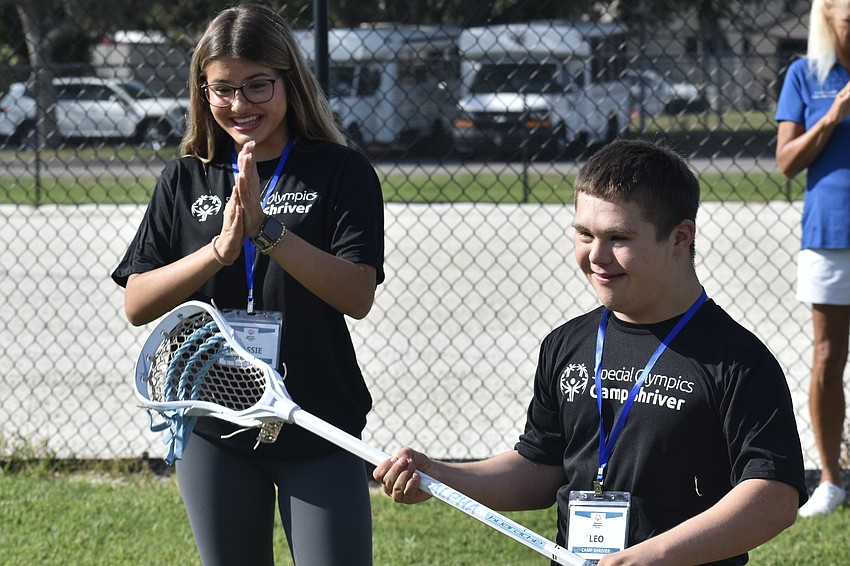 Cassie Smith, a senior, works with Leo, 15, on lacrosse.