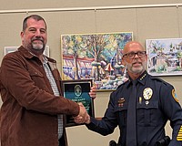 Longboat Key Police Chief Russ Mager (right) presents Lee Smith with a plaque recognizing his years with the police department at the June 1 Town Commission meeting. Smith retired from his position as sergeant on May 29.