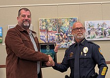 Longboat Key Police Chief Russ Mager (right) presents Lee Smith with a plaque recognizing his years with the police department at the June 1 Town Commission meeting. Smith retired from his position as sergeant on May 29.