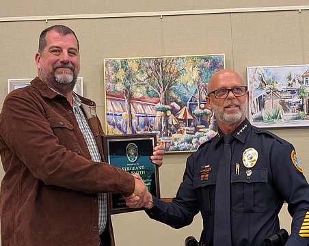 Longboat Key Police Chief Russ Mager (right) presents Lee Smith with a plaque recognizing his years with the police department at the June 1 Town Commission meeting. Smith retired from his position as sergeant on May 29.