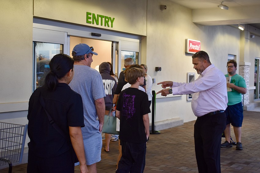 Store Manager Josh Jordan asks a couple kids if they're 14 years old yet because that's the minimum age to be a bagger.