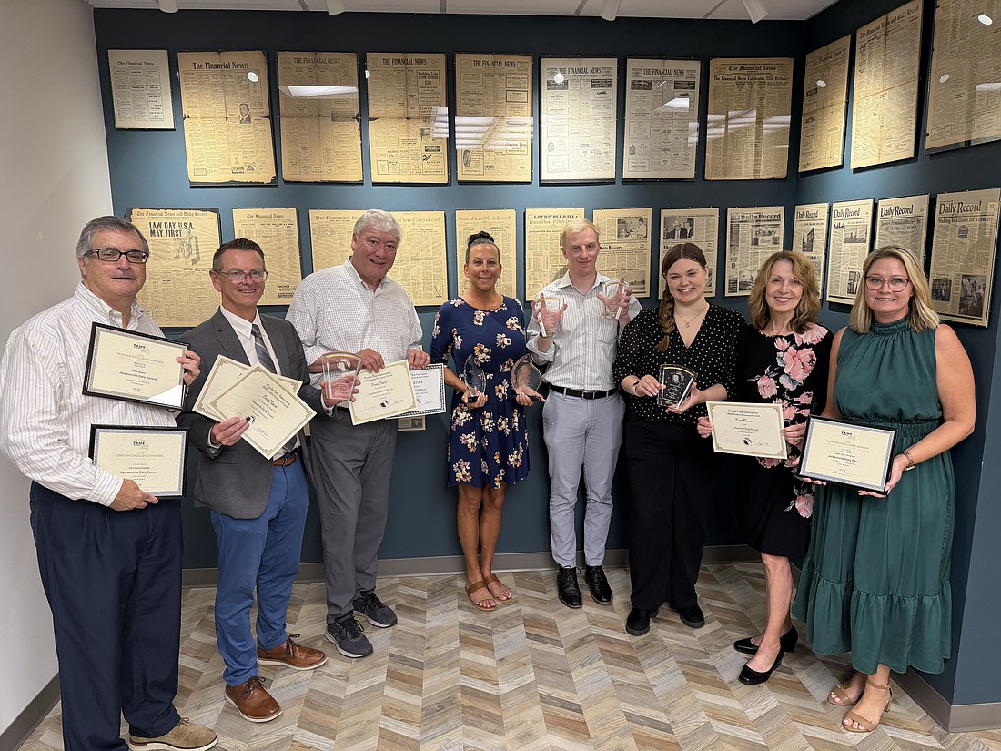 Jacksonville Daily Record staff members display awards won by the publication at the 2026 Florida Media Conference. The Daily Record won 16 awards for editorial and advertising excellence. From left are: Stephen Reynolds, multimedia advertising consultant; Ric Anderson, editor; Dan Macdonald, staff writer; Codi Rinehart, graphic designer; Joe Lister, staff writer; Kaili Cochran, news designer; Karen Brune Mathis, editor at large; and Angie Campbell, publisher.