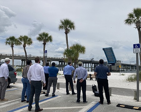 A drone flies over the Longboat Pass Bridge at an 80-foot elevation to contextualize what a fixed-span bridge would look live over the pass. Looking on (from left to right) are Longboat Key Commissioner Steve Branham, FDOT Southwest Area Office Director Wayne Gaither, FDOT Professional Engineer Trainee Stephen Pack, FDOT Project Manager David Turley, FDOT Project Development Manager Jimmy Vilce, FDOT Interim District One Secretary Jamie Driggers, Longboat Key Town Manager Howard Tipton and Longboat Key IT Director Jason Keen.