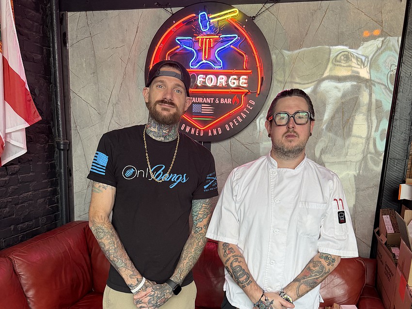 The Forge Restaurant & Bar co-owner and general manager Mathew Bush and chef Eric Hamilton stand in front of the establishment’s neon logo. The Forge, 1198 Edgewood Ave. S., has scheduled a soft opening on June 12.