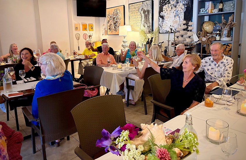 Rotarians raise their glasses in cheers to their new president Terri Driver, who agreed to serve a second term.