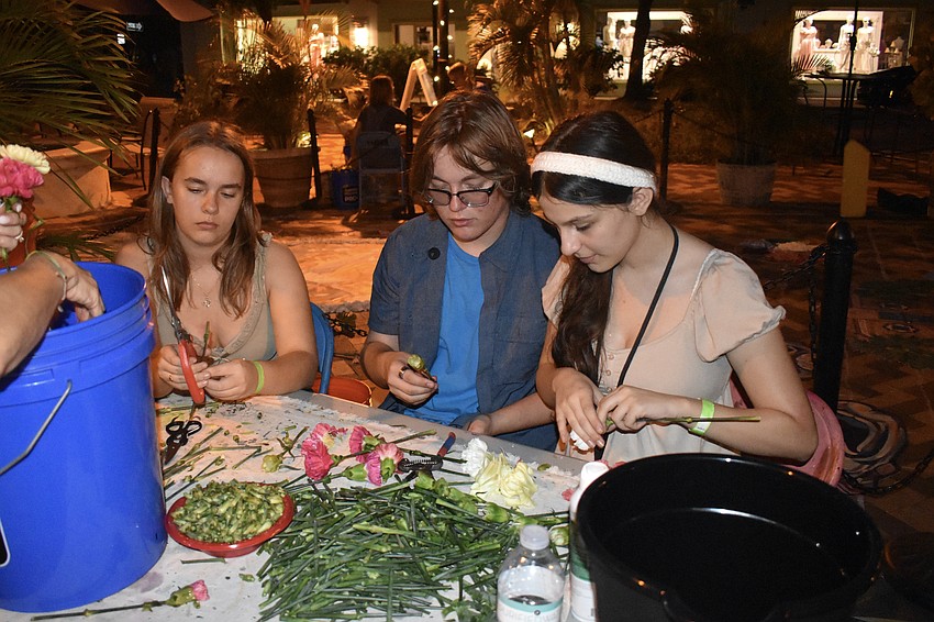 Morgan Wilkins-Plumley, 14, Chance Lett, 16, and Alexa Villegas, 15, work on the materials for the infiorata.