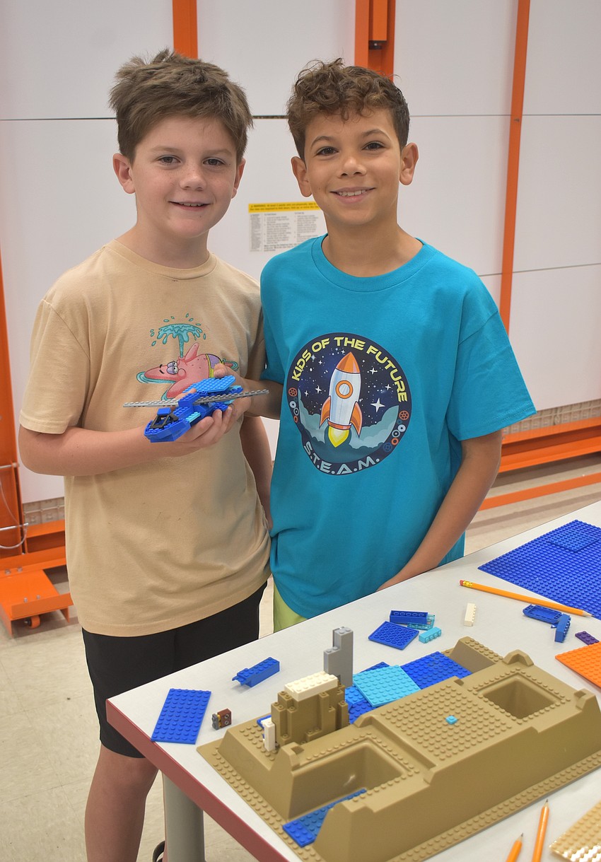Harrison Rimer, a rising fourth grader at Braden River Elementary School, and Adrian Vargas, a rising fifth grader at B. D. Gullett Elementary School, create an ice dragon habitat out of Legos which includes icy mountains, a large open space, water source, large prey and a protected den.