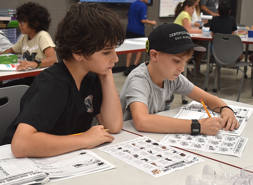 Draven Kramer, a rising seventh grader at Pine View School, and Colton Logan, a rising seventh grader at St. Mary Academy, work together to identify different animal skulls.