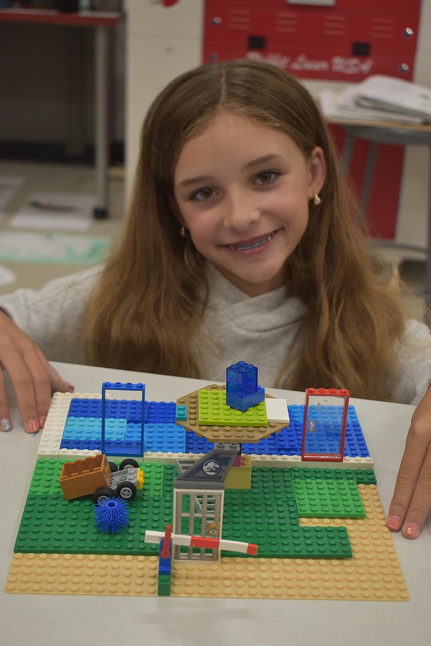 Ella Volpe, a rising fourth grader at Woodland Academy, shows off her cave frog habitat which includes dark caves, fresh water pools, small insects, a rocky shelter and cool temperatures.