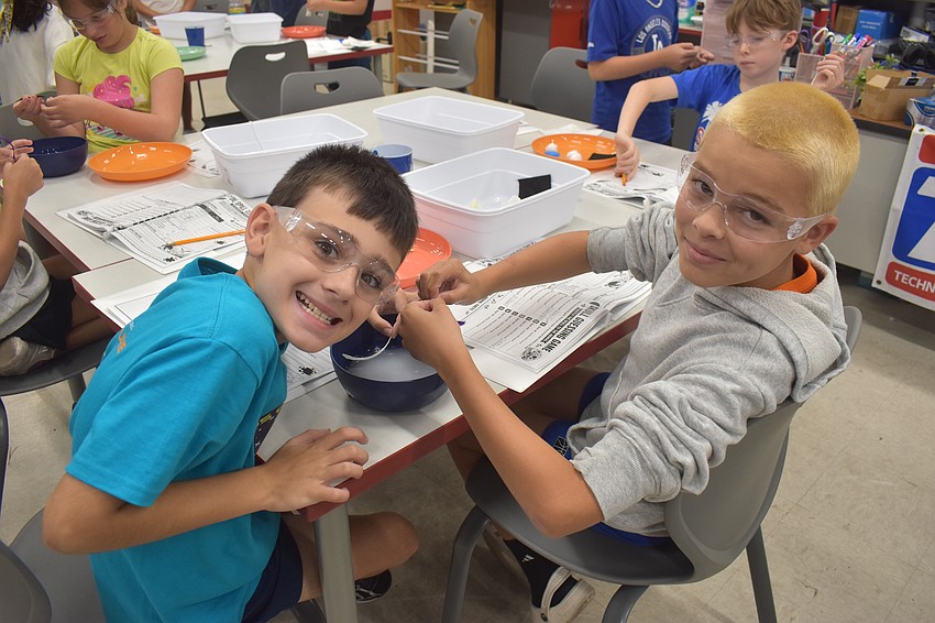 Owen Quisenberry, a rising fourth grader at Tatum Ridge Elementary School, and Eli Bergan, a rising fourth grader at Lake Manatee K-8, work on cleaning their oil-covered feathers as part of the oil-spill challenge.