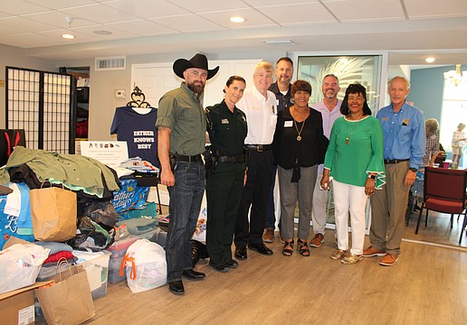 Palmetto community leaders showed up strong at Longboat Island Chapel's latest charity drive to support Mt. Carmel Resource Center on June 16. From left, Deputy Ken Jewett, Sgt. Joy Jewett, Chief of Police Scott Tyler, City of Palmetto Mayor Daniel West, Shirley Pearson, executive director of Strength in Action, Inc., Rev. Brock Patterson, Pearson's sister Laura Wallace, and Town of Longboat Key Town Manager Howard Tipton.