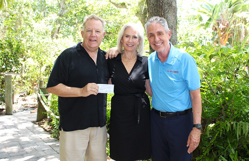 The Miracle League of Manasota Executive Director Chris Cushman accepts a $3,500 donation from Kiwanis Club of Longboat Key President Danielle Gladding and Past President Michael Garey from the latest pancake breakfast fundraiser. The league is the club's newest charitable partner.