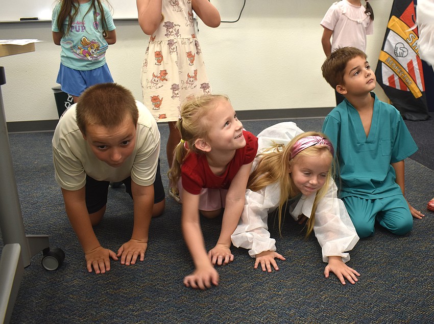 Connor Barreiro, Audrey Olivarri, Emery Arrington and Cooper Heim pretend to be dogs and use their sense of smell to locate incense sticks at the Little Vet School camp.
