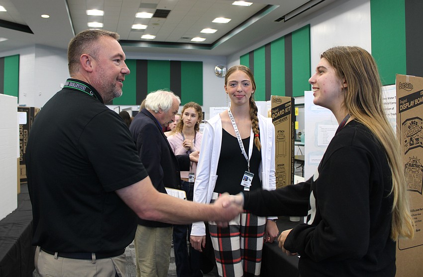 Dustin Dahlquist, who was the Lakewood Ranch High Principal and will now be founding principal of Rangeland High, congratulates senior Payton Casto after she presented her marine science project with her project teammate senior Gianna Weldon at a science fair Dec. 11. Dustin Dahlquist, who was the Lakewood Ranch High Principal and will now be founding principal of Rangeland High, congratulates senior Payton Casto after she presented her marine science project with her project teammate senior Gianna Weldon at a science fair Dec. 11.