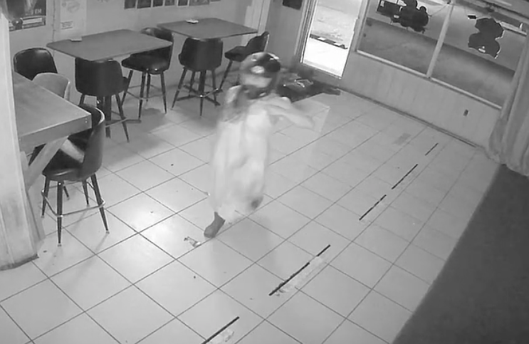 Footage from 8 Ball Lounge security footage shows a woman in a motorcycle helmet moments after stepping through the front door she broke. Footage from 8 Ball Lounge security footage shows a woman in a motorcycle helmet moments after stepping through the front door she broke.