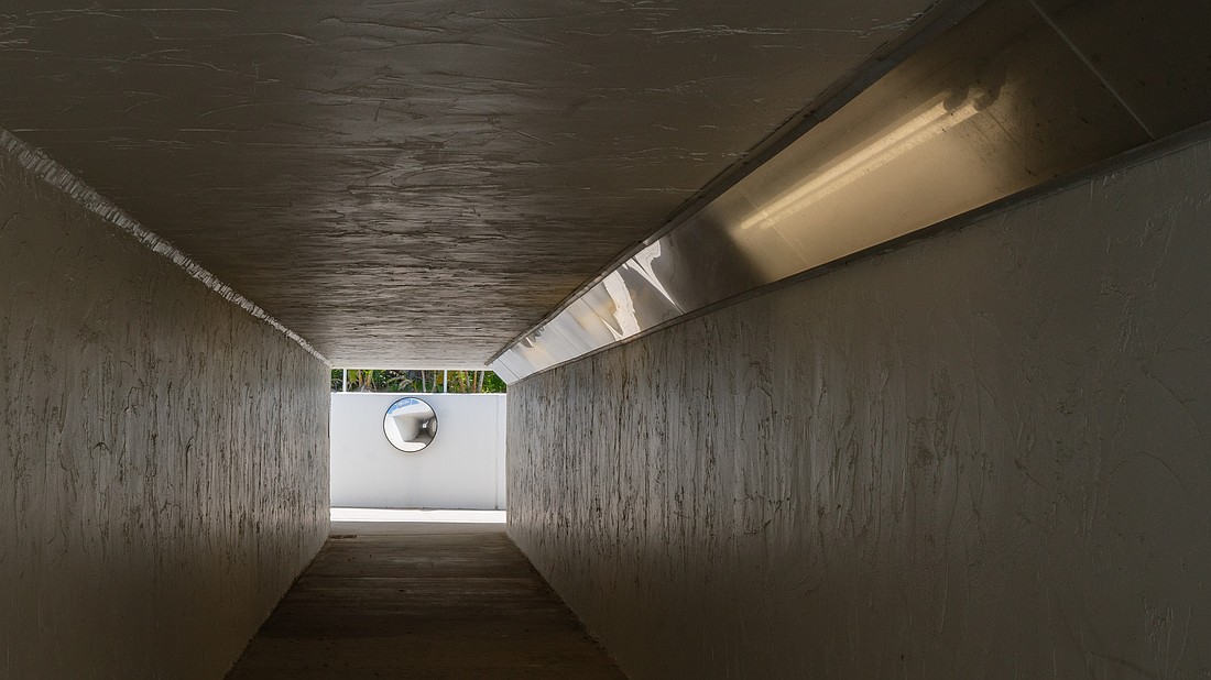 The pedestrian tunnel under State Road 789, locally known as Gulf of Mexico Drive, is illuminated by fluorescent lights.
