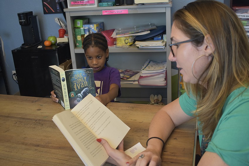 Second grader Lamaud Alexis reads with teacher Erin Foss at Star Lab.