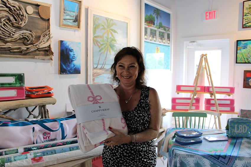 Irina LaRose, co-owner of Design2000, poses with featured Little Blue Designs pieces at The Studio.