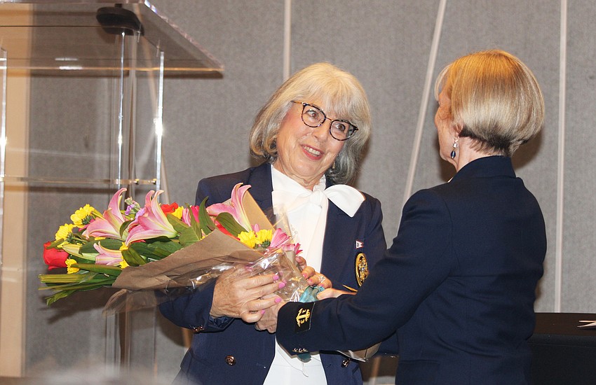 Debra Landesberg accepts flowers from Bird Key Yacht Club Vice Commodore Lynne Pettigrew.
