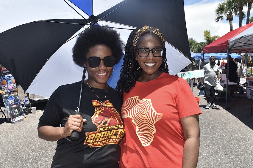 Keanna Newman and Fayth Jenkins stay cool under an umbrella.