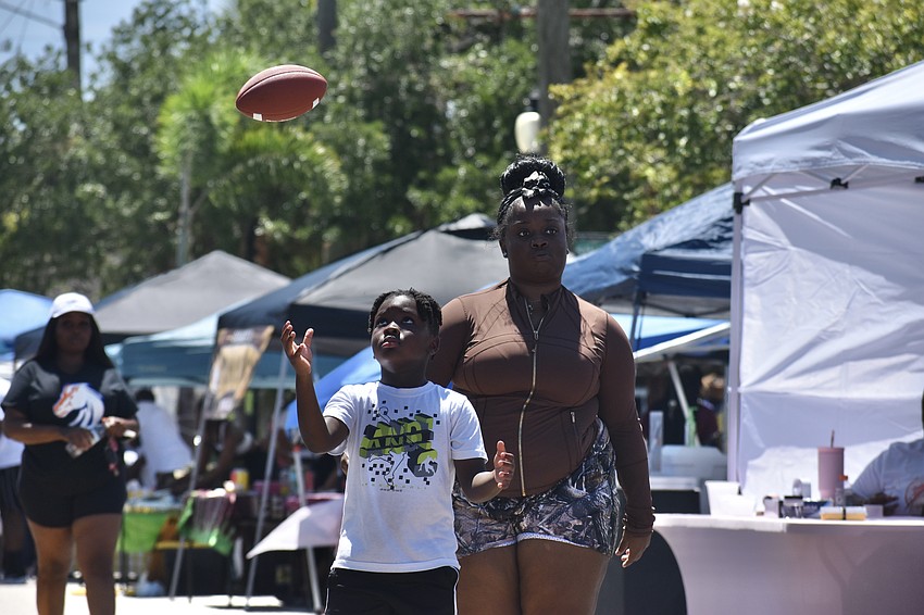 Ace Hood, 6, tosses a football while he walks alongside Modesty Williams.