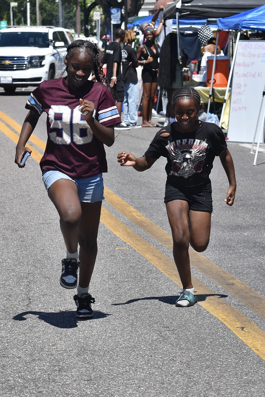 Beaute Martin, 12, and Kailani Bowman, 9, run through the festival area.