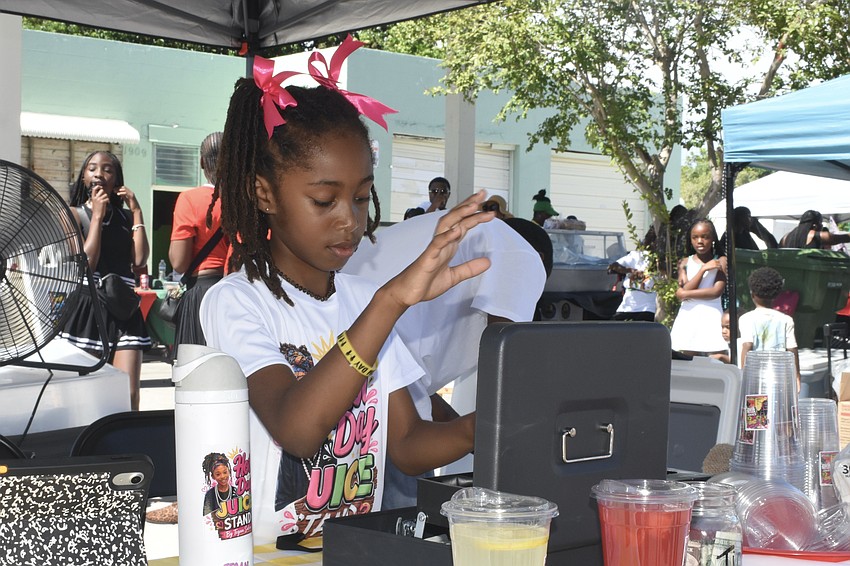 Tegan Salem, 8, works the counter at Hot Day Juice Stand.