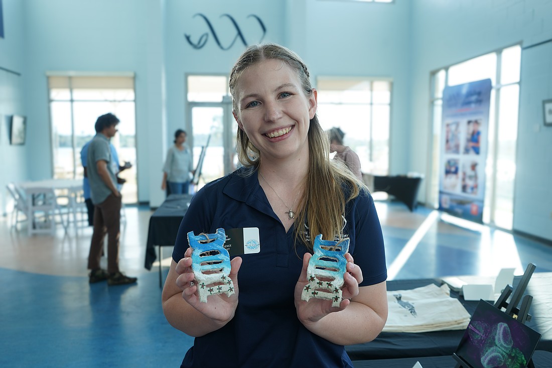 Graduate student Emily Skinner holds up her DNA sand creations. Photo by Rachel Mills