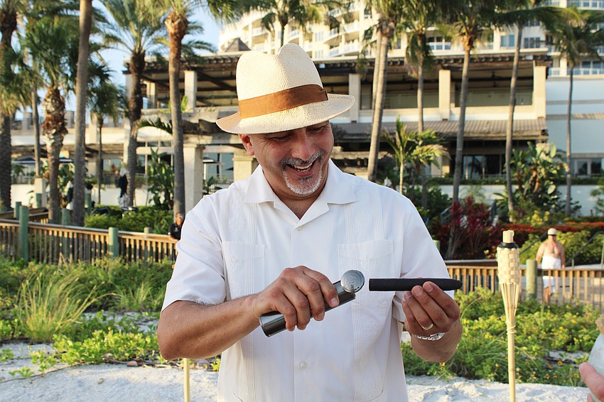 Leo Echevarria puts the finishing touches on a freshly rolled cigar at the Lido Key Tiki Bar reopening.