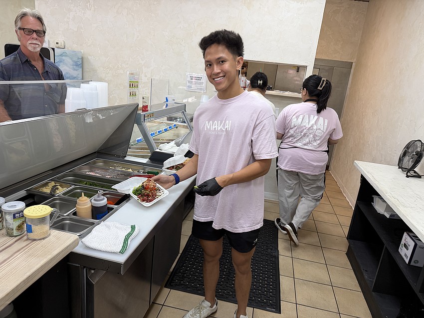 Co-owner Nate Ferrer holds a combination poke with ahi tuna and salmon made at Makai, which opened June 4.